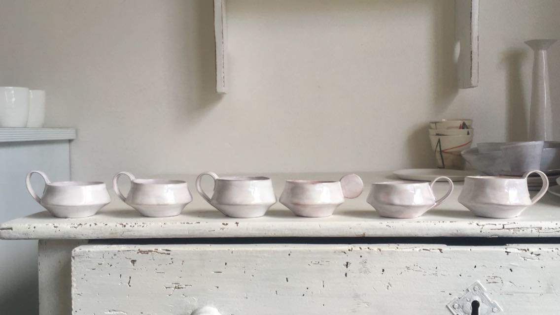 Row of ceramic bowls on a white surface with a neutral background